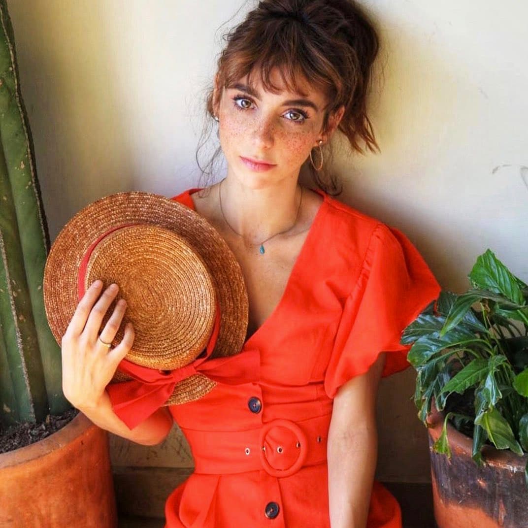 Siguiendo con la tendencia de prendas ligeras y coloridas, Natalia usó un vestido naranja de Almu de la Torre que combinó a la perfección con unas arracadas doradas y un sombrero con un moño de dicho tono.