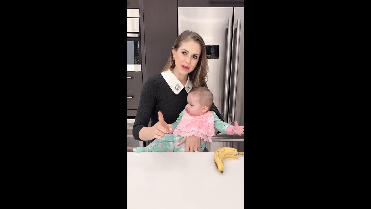 La cocina está forrada por muebles de color caoba oscuro y electrodomésticos de acero inoxidable, los cuales están empotrados.