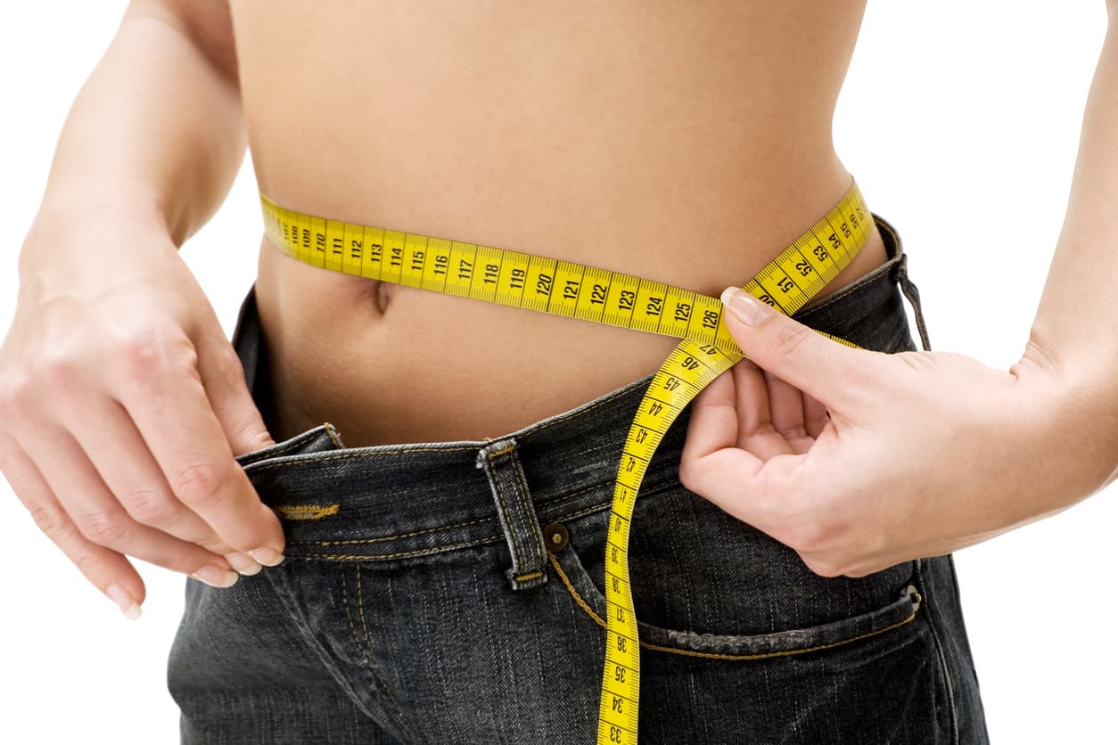 Woman measuring her waist. Isolated on a white background.